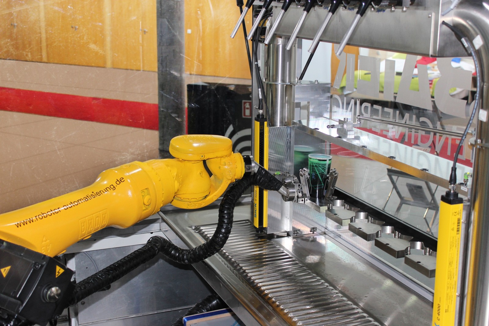 Der KR16 der Cybertech Familie bereitet Drinks in der Roboterschankanlage wie ein Barkeeper zu.