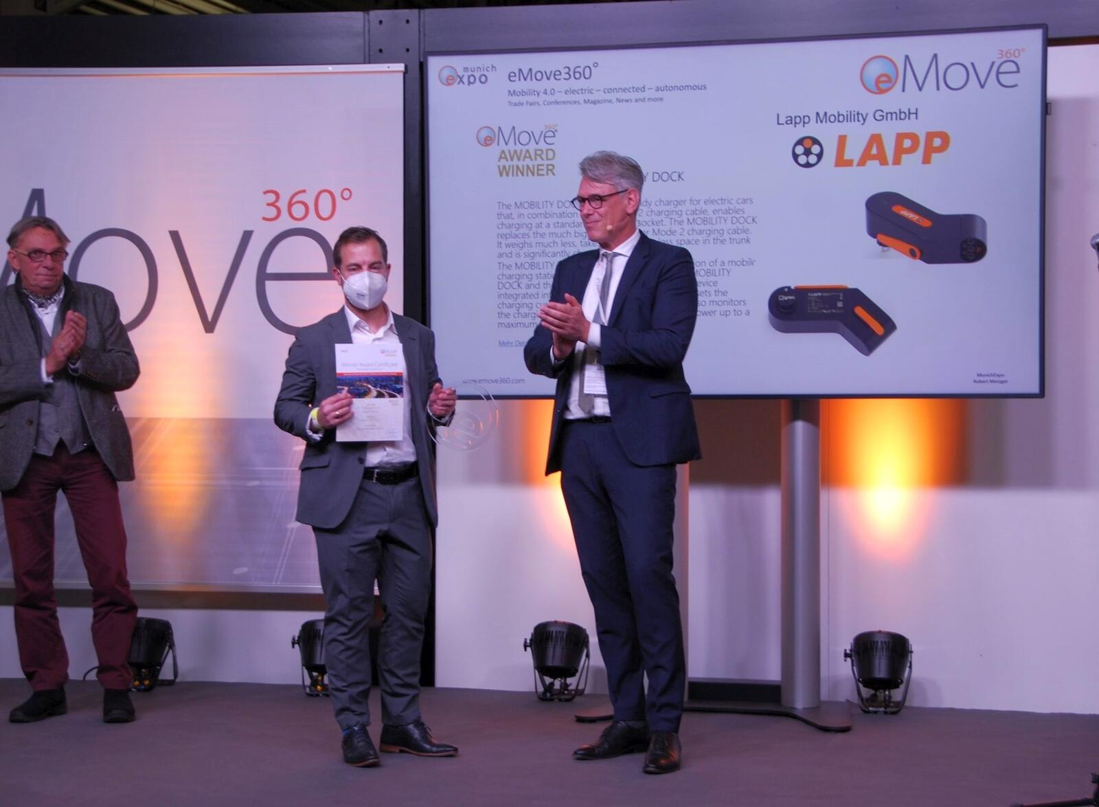 Robert Metzger (re.), CEO & Publisher der Munich Expo Veranstaltungs GmbH, übergibt an Fabian Gläser (Mitte), Projektmanager Lapp Mobility GmbH, den Emove 360 Award. 
