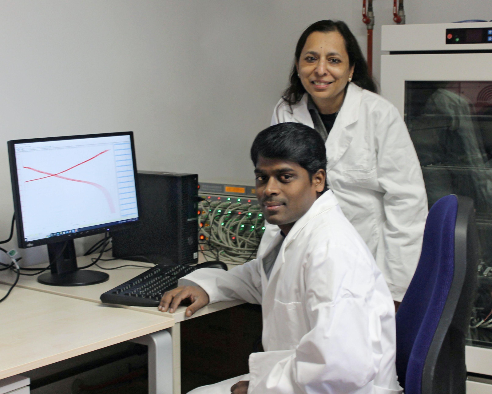 Dr. Sivaraj Pazhaniswamy (vorn) und Prof. Dr. Seema Agarwal an einer Anlage für Batterietests in einem Bayreuther Labor für Makromolekulare Chemie.